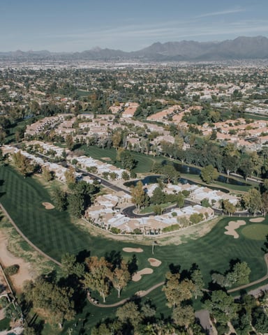Arizona suburban landscape with trees and buildings under blue sky