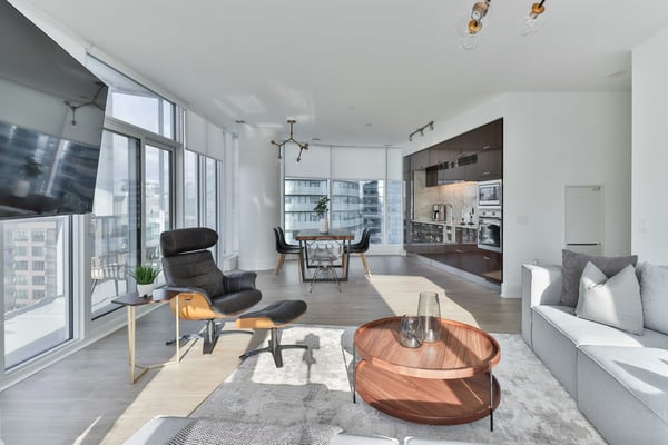 Bright high-rise apartment living room with floor-to-ceiling windows, city views, and contemporary furniture